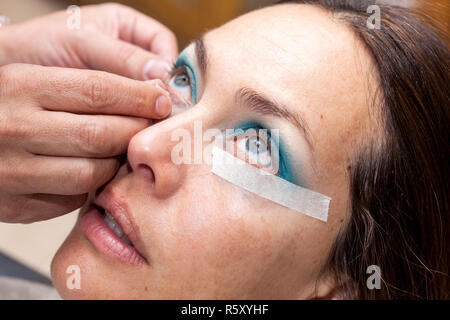 Make up Artist usando del nastro adesivo protettivo per la creazione di occhi di gatto Foto Stock