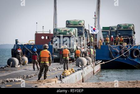 ROK marinai e soldati coordinare l'offload di veicoli dal Navy Pier alleggio durante il funzionamento del pacifico esercizio di raggiungere 2017 (OPRex17). OPRex17 è un accordo bilaterale per l'evento di formazione progettati al fine di garantire la preparazione e sostenere la Rok-STATI UNITI Alliance esercitando un'area Distribution Center (ADC), un terminale Aria punto di alimentazione (ATSP), Combined Joint Logistics Over-the-Shore (CJLOTS), e l'uso della ferrovia, vie di navigazione interna e costiera operazioni di sollevamento per convalidare il funzionamento concetto reach. Foto Stock