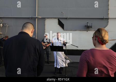 Golfo di Aden (16 aprile 2017) il cappellano, Lt. La Cmdr. Jay Kersten conduce una speciale Pasqua Alba servizio sul ponte di volo dell'assalto anfibio nave USS Bataan (LHD 5). La nave e il suo gruppo di pronto, sono distribuiti negli Stati Uniti Quinta Flotta area di operazioni a sostegno della sicurezza marittima operazioni destinate a rassicurare gli alleati e partner e preservare la libertà di navigazione e il libero flusso di commercio nella regione. Foto Stock