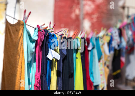 Vestiti variopinti impiccato ed essiccamento in una linea all'aperto una casa, Pylos, Grecia. Foto Stock