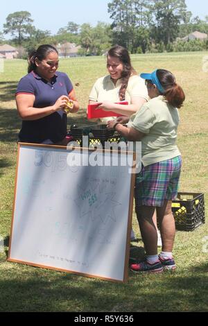 Demaree irlandese (sinistra), un medico Assistente di supporto a Fort Stewart, Ga., raccoglie palline da golf da membri della Comunità di Marne e coniugi Club (MCSC) presso l'organizzazione del quarto annual Golf Scramble Aprile 21, 2017 a Taylors Creek Golf Course a Fort Stewart. MCSC ha ospitato la codifica per raccogliere fondi per la concessione di sovvenzioni e borse di studio il gruppo presenta a Marne scuole comunitarie e organizzazioni. Foto Stock