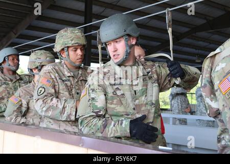 Stati Uniti I soldati assegnati al combattimento 982nd fotocamera Company, il 824th Quartermaster Company e l'esercito degli Stati Uniti per gli affari civili e le operazioni psicologiche del comando azioni pratiche sul velivolo a Papa Army Airfield situato in Fort Bragg, NC, 21 aprile 2017. Stati Uniti I soldati assegnati al combattimento 982nd fotocamera Company, il 824th Quartermaster Company e l'esercito degli Stati Uniti per gli affari civili e le operazioni psicologiche Il comando si stavano preparando per un salto in paracadute da un C-130 Hercules aeromobili in Sicilia nella zona di caduta si trova a Fort Bragg, NC. Foto Stock