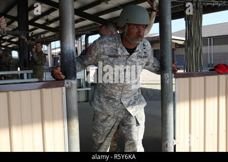 Stati Uniti Army Chief Warrant Officer John Harris, a destra, un jumpmaster assegnato alla 824th Quartermaster Company, ispeziona i al di fuori di una simulazione di C-130 Hercules aerei durante il paracadute le azioni di formazione condotte a Papa Army Airfield situato in Fort Bragg, NC, 21 aprile 2017. Stati Uniti I soldati assegnati al combattimento 982nd fotocamera Company, il 824th Quartermaster Company e l'esercito degli Stati Uniti per gli affari civili e le operazioni psicologiche Il comando si stavano preparando per un salto in paracadute da un C-130 Hercules aeromobili in Sicilia nella zona di caduta si trova a Fort Bragg, NC. Foto Stock