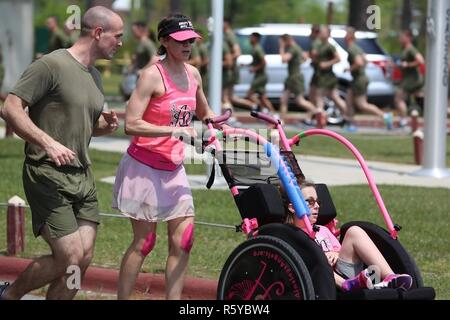 Marines correre lungo il lato guide di volontariato durante una formazione girare al Marine Corps Air Station New River, N.C., 13 aprile 2017. Più di 220 marines assegnato a Marino Logistica Aerea Squadron 26, Marine Aircraft Group 26, seconda Marine Ala di aeromobili si sono riuniti per eseguire con figli disabili come parte di un Ainsley's Angels East Carolina capitolo evento presso la stazione di aria. Ainsley's Angels è un organizzazione che si concentra sulla fornitura di bambini con disabilità l'opportunità di essere inclusi in percorsi che la gamma di distanze da 5k fino a 50k. I volontari sono assegnati come angeli per spingere l'atleta piloti un Foto Stock