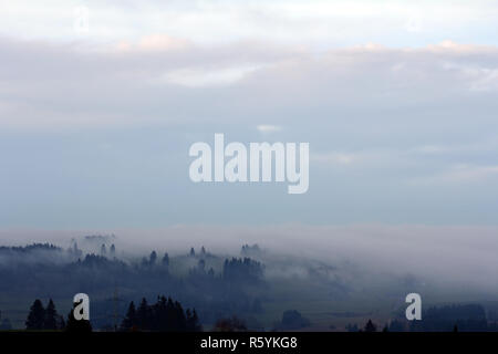 Nebbia autunnale bavarese. in serata la nebbia tira su il paesaggio di sera Foto Stock