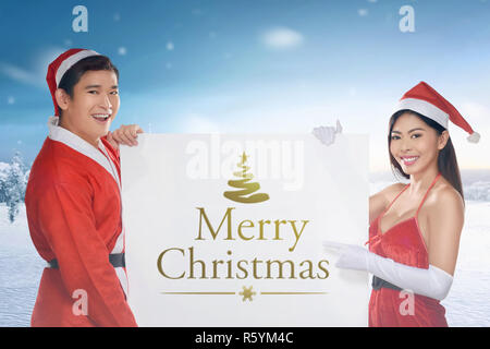 Asian giovane indossando il costume di santa azienda banner Foto Stock