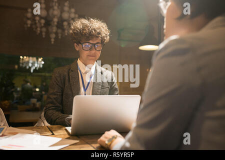 Smart utilizzando il programmatore portatile in ufficio scuro Foto Stock
