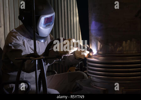 Saldatore con maschera protettiva in metallo di saldatura e le scintille Foto Stock