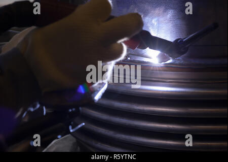 Saldatore con maschera protettiva in metallo di saldatura e le scintille Foto Stock