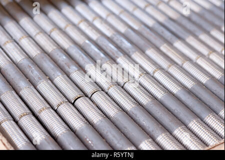 Tubi filettati con filettature. in produzione. pezzi finiti in una riga Foto Stock