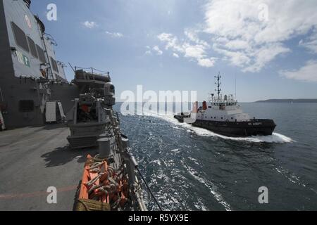 PLYMOUTH, Regno Unito (21 aprile 2017) - un rimorchiatore a traino guide USS Carney (DDG 64) in al porto di Plymouth, Regno Unito come la nave partecipa a bandiera Officer Sea allenamento Aprile 21, 2017. Carney, un Arleigh Burke-class guidato-missile distruttore, distribuita a Rota, Spagna, sta conducendo la sua pattuglia di terzi negli Stati Uniti Sesta flotta area di operazioni a sostegno degli Stati Uniti per gli interessi di sicurezza nazionali in Europa. Foto Stock