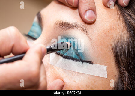 Make up Artist usando del nastro adesivo protettivo per la creazione di occhi di gatto Foto Stock