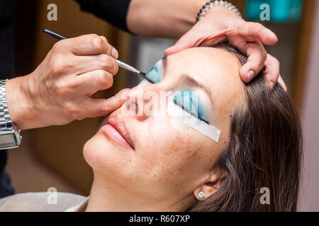 Make up Artist usando del nastro adesivo protettivo per la creazione di occhi di gatto Foto Stock