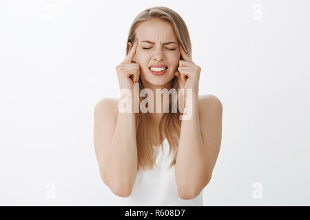 Comune di ottenere i vostri pensieri insieme. Ritratto di intensa e pressioni giovane donna con capelli biondi di essere in difficoltà a pensare come piano di fuga terribile Foto Stock