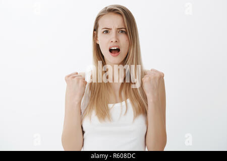 Studio shot di donna realizzare ha perso essere rimasto scioccato e devestated come in piedi con rinserrata pugni, sperando per la vittoria alla ricerca disperata in telecamera w Foto Stock