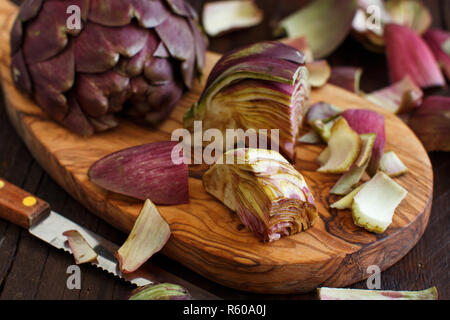 Carciofi romani su una tavola di legno Foto Stock