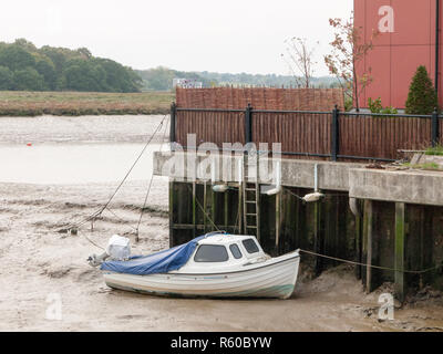 Parcheggio privato bianco barca nel fango alla fine del dock Foto Stock