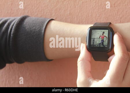 Donna che utilizza smart watch (Fitbit) Foto Stock