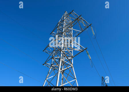 Supporta le linee elettriche ad alta tensione contro il cielo blu Foto Stock