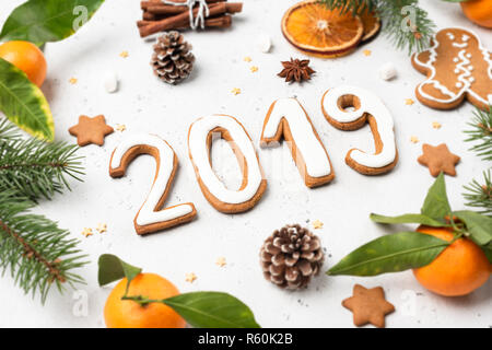 2019 fatta di gingerbread cookie e decorazioni su cemento bianco sullo sfondo. Natale o Capodanno Saluto modello di scheda Foto Stock