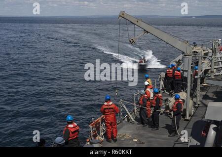 Oceano atlantico (26 aprile 2017) - i marinai in una rigida-scafo gommone ritorno alla Arleigh Burke-class guidato-missile destroyer USS Carney (DDG 64) dopo il recupero di un manichino di formazione durante un uomo a mare esercizio durante la partecipazione a Flag Officer Sea allenamento Aprile 26, 2017. Carney, distribuita a Rota, Spagna, sta conducendo la sua pattuglia di terzi negli Stati Uniti Sesta flotta area di operazioni a sostegno degli Stati Uniti per gli interessi di sicurezza nazionali in Europa. (U.S. Foto di Marina di Massa lo specialista di comunicazione di terza classe Weston Jones/rilasciato) Foto Stock