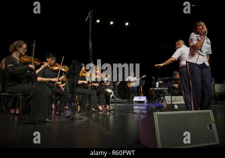 Il personale Sgt. Ainsley Davis, U.S. Forze Aeree del comando centrale vocalist di banda, canta durante un concerto insieme con la comunità di Doha Orchestra presso la scuola americana di Doha, Aprile 29, 2017. Gli Stati Uniti Le forze di aria di comando centrale di banda è il primo permanentemente assegnato Air Force Band alla centrale di comando Area di responsabilità. In base Al Udeid Air Base, Qatar, la banda è compresa di distribuito aviatori da active duty, Riserva e Air National Guard bande. Foto Stock