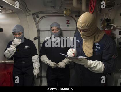 Mare Mediterraneo (27 aprile 2017) Macchine aggiustatore di prima classe William Arroyo prende muster a bordo del Arleigh Burke-class guidato-missile destroyer USS Ross (DDG 71) durante un quartieri generali trapano. Ross è distribuita a Rota, Spagna, conducendo operazioni navali negli Stati Uniti Sesta flotta area di operazioni a sostegno degli Stati Uniti per gli interessi di sicurezza nazionali in Europa e in Africa. Foto Stock