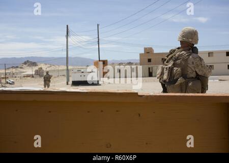 Stati Uniti Marines con terzo plotone, Fox Company, 2° Battaglione, 6° Reggimento Marine, pattugliare una strada mentre conducendo operazioni militari nel Terreno urbano (MOUT) per Taloni Esercizio (TalonEx) 2-17, ventinove Palms, ca., 26 aprile 2017. Lo scopo di TalonEx era per la massa unità di combattimento di condurre la formazione integrata nel supporto di armi e tattiche corso istruttori (WTI) 2-17 ospitato da aviazione marina di armi e tattiche di uno squadrone (MAWTS-1). Foto Stock