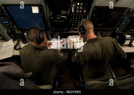 Stati Uniti Air Force Il Mag. Izzy Remo, sinistra, un conduttore di prova-airborne, E DEGLI STATI UNITI Air Force Capt. Greg Carter, a destra di un vice-missile equipaggio combat commander-airborne, sia dai conti nella 625 a operazioni strategiche Squadron, andare oltre il lancio di missili durante le procedure di volo gloria 220 sopra l'Oceano Pacifico, 26 aprile 2017. Gloria Viaggio è operativo un test di lancio che continua una lunga storia di Gamma Western lancia utilizzata per verificare e convalidare e migliorare la capacità della nazione di forza di missili a gittata intercontinentale. Foto Stock