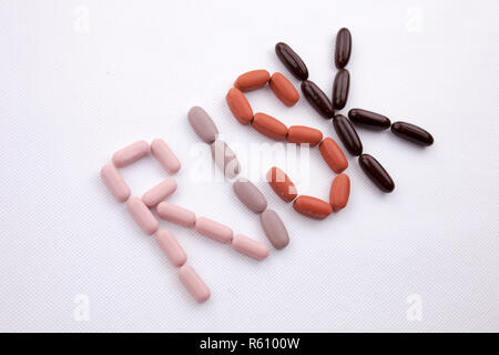 Mano concettuale di scrittura di testo Didascalia ispirazione cure mediche concetto di salute scritta con farmaci pillole capsule parola rischio bianco su sfondo isolato con spazio di copia Foto Stock