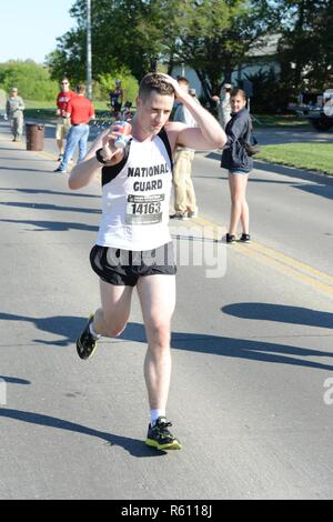 Protezione superiore Runner: 1Lt. Kenneth Rayneri, comandante del distretto di Columbia esercito Guardia nazionale presso la sede centrale e la sede di distacco, 74a comando di truppa, versa acqua su se stesso di rimanere fresco mentre si avvicina il punto mediano del Lincoln Guardia Nazionale Maratona in Lincoln, Neb., su un caldo Maggio 7 giorno. Rayneri ha vinto la Guardia Nazionale maschio del titolo di divisione con un tempo di 2 ore, 42 minuti e 47 secondi. (Nebraska Guardia Nazionale Foto Stock