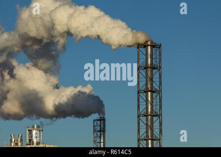Comignoli fumanti legno impianto di lavorazione su uno sfondo di cielo blu Foto Stock