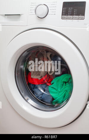 Moderna macchina lavatrice automatica caricato con abiti colorati Foto Stock