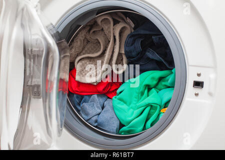 Moderna macchina lavatrice automatica caricato con abiti colorati Foto Stock