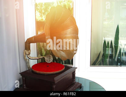 Dispositivo musicale / vecchio grammofono con la piastra o disco di vinile su una scatola di legno Foto Stock