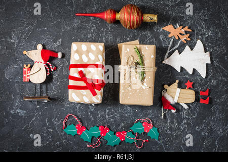 Composizione di natale. Regali di Natale, giocattoli su pietra nera dello sfondo. Appartamento laico, vista dall'alto. Foto Stock