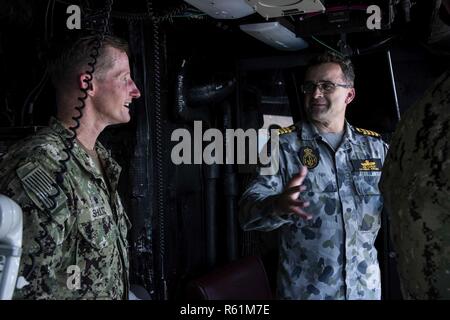 PORT MORESBY, Papua Nuova Guinea (nov. 16, 2018) Capt. Jon precoce, comandante della Royal Australian Navy atterraggio elicottero nave dock HMAS Adelaide (L01), e il cap. Tom Shultz, comandante del trasporto anfibio dock nave USS Green Bay (LPD 20), conversare in elicottero torre del Green Bay durante un tour. Green Bay è in Port Moresby per assistere con gli sforzi di protezione davanti alla Cooperazione economica Asia-Pacifico (APEC) conferenza ed è la seconda nave americana a visitare Port Moresby negli ultimi due mesi. Green Bay è parte del squadrone anfibio 11 ed è operativo nel re Foto Stock