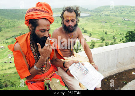 Un sadhu fumo una sigaretta a Trimbakeshwar, vicino Nasik durante il Kumbh Mela 2003, Maharashtra, India. Foto Stock