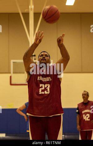 Un atleta degli Special Olympics spara una palla da basket durante le Hawaii Special Olympics, Marine Corps base Hawaii, nov. 19, 2018. Special Olympics offre tutto l'anno corsi sportivi e la competizione atletica in una varietà di discipline olimpiche sport per i bambini e gli adulti con disabilità intellettiva. Questo dà loro opportunità di continuare a sviluppare il benessere fisico, dimostrare coraggio, esperienza di gioia e di partecipare a una condivisione di doni, di competenze e di amicizia con le loro famiglie, altri gli atleti degli Special Olympics e la comunità. Foto Stock