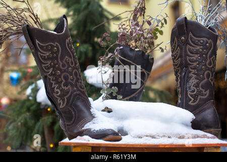 Onorevoli pelle vintage scarpe cowboy coperte di neve. Moda per donna stivali. Foto Stock