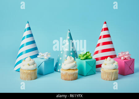 Parte colorata caps,doni e gustosi tortini su sfondo blu Foto Stock