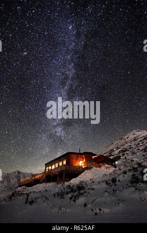 Via lattea durante l'inverno paesaggio di montagna con cottage, Slovacchia Tatra Foto Stock