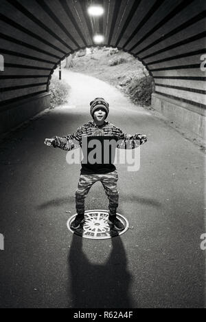Ragazzo di nove anni in Driprock Arch, Central Park di New York City, Stati Uniti d'America. Foto Stock