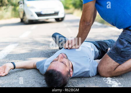 L'uomo riceve il primo soccorso dopo un incidente di automobile Foto Stock