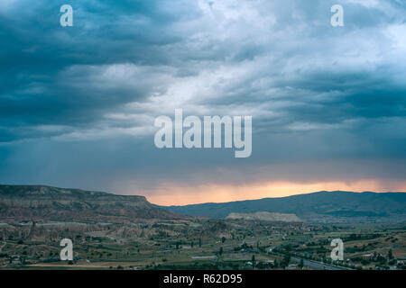 Vista pittoresca del paesaggio naturale della Cappadocia in Turchia contro lo sfondo di un cielo drammatico e al tramonto. Foto Stock