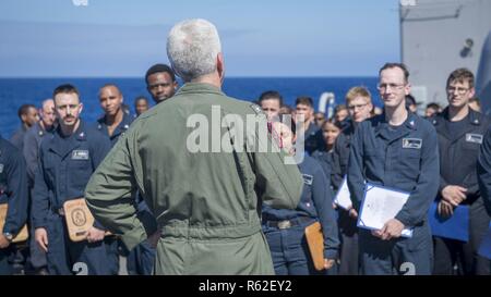 Mare delle Filippine (nov. 17, 2018) posteriori Adm. Karl O. Thomas, commander, battle force settima flotta, parla all'equipaggio della Ticonderoga-class guidato-missili cruiser USS Chancellorsville (CG 62) sul castello di prua durante una visita programmata. Chancellorsville è distribuita negli Stati Uniti 7 flotta area di operazioni a sostegno della sicurezza e della stabilità nella regione Indo-Pacifico. Foto Stock