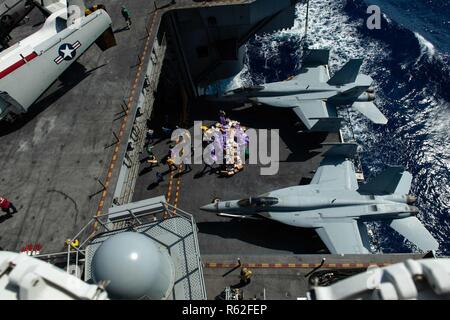 Mare delle Filippine (nov. 17, 2018) marinai spostare la posta da un aeromobile ascensore nell'hangar bay durante una chiamata posta a bordo della Nimitz-class portaerei USS John C. Stennis (CVN 74). John C. Stennis è in corso e la conduzione di operazioni in acque internazionali come parte di un vettore doppio sciopero vigore esercizio. Gli Stati Uniti Marina ha pattugliato l'Indo-Pacifico regione di routine per più di 70 anni di promuovere la sicurezza regionale, la stabilità e la prosperità. Foto Stock