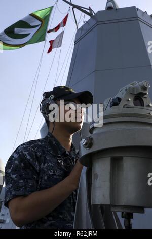 181121-N-DX072-1013 Cairns, Australia (nov. 21, 2018) Quartermaster marinaio Vincentius Clark, da Jakarta, Indonesia, sorge a dritta ponte-ala lookout guardare durante un mare e ancora in evoluzione come il trasporto anfibio dock nave USS Green Bay (LPD 20) arriva in Cairns, Australia per una visita di porta. Green Bay, parte del comandante squadrone anfibio 11, è operativo nella regione per migliorare l'interoperabilità con i partner e servire come una pronta risposta in vigore per qualsiasi tipo di emergenza. Foto Stock