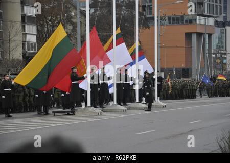 Soldati lituani preparare per sollevare più bandiere nazionali durante il centenario sfilata di ristabilimento dell'esercito lituano di Vilnius, Lituania, nov. 24, 2018. Più di 20 nazioni hanno partecipato al secolo lituano parata e la loro proclamazione di indipendenza dall'impero russo. Foto Stock