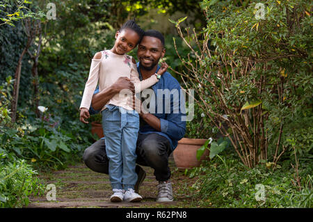 Padre che tiene la figlia in abbraccio mentre cammina sul prato della  foresta Foto stock - Alamy